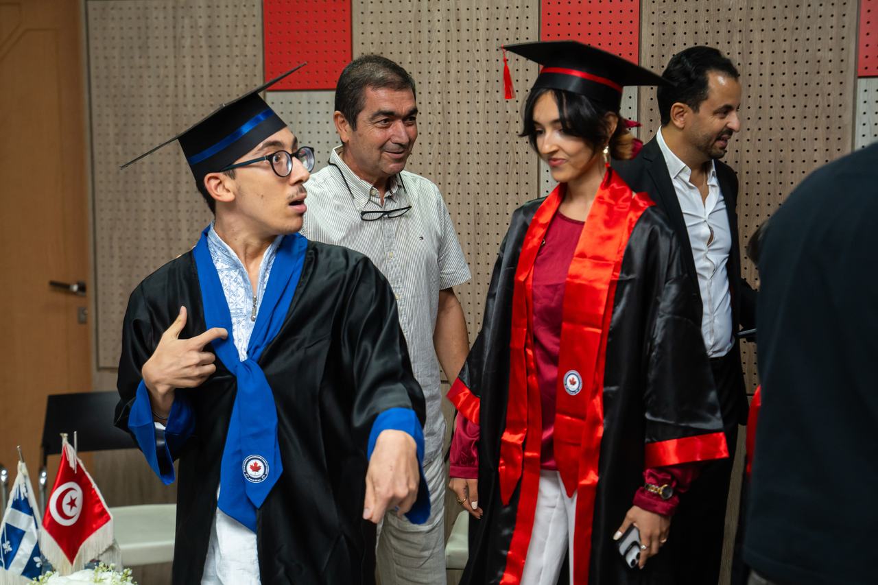 Des diplômés en toge et mortier, diplôme en main
