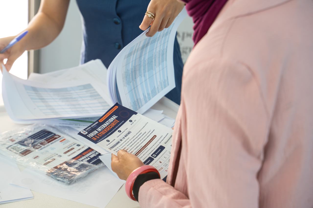 Mains tenant le programme et les documents du forum