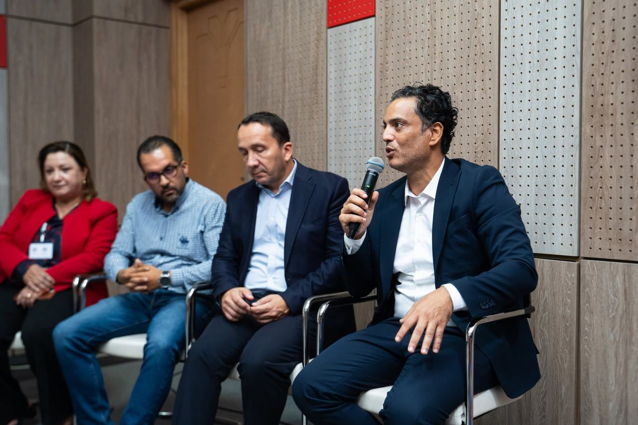 Quatre intervenants d'un panel, l'un d'eux au micro