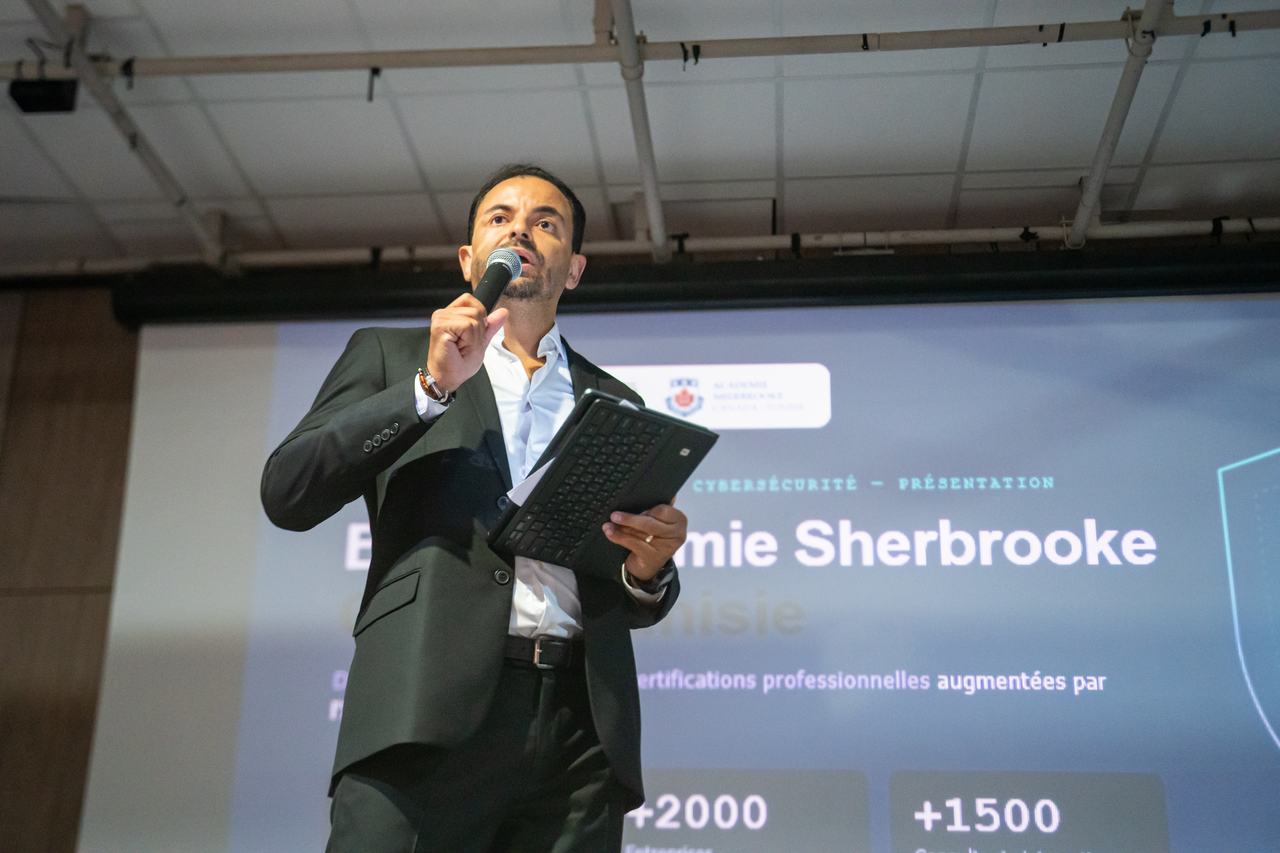 Un intervenant présente l'Académie Sherbrooke Canada-Tunisie, diapositive projetée derrière lui