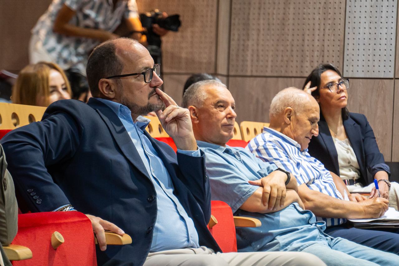 Des participants assis au premier rang, attentifs