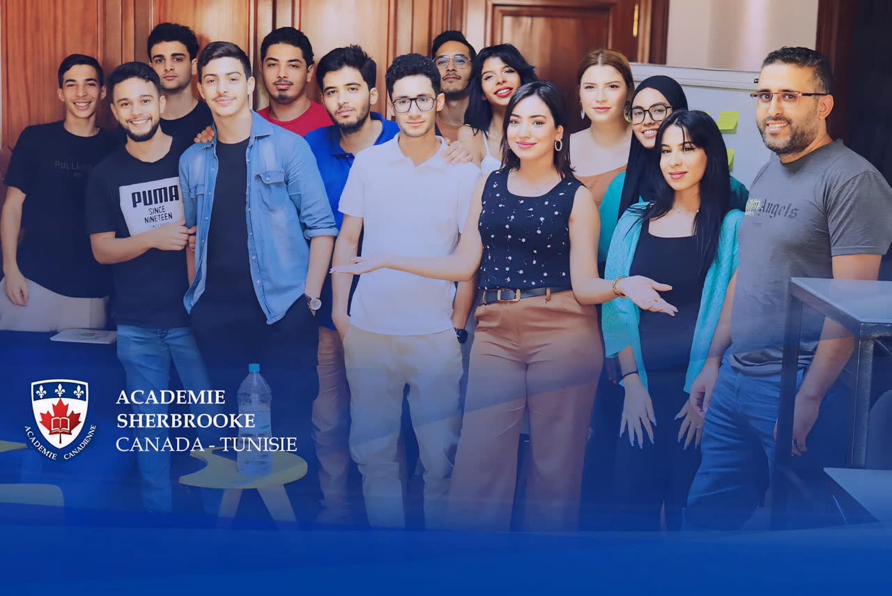 Groupe d'étudiants posant devant la bannière de l'académie